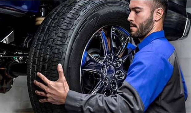 Certified Ford Service Technician performing tire change